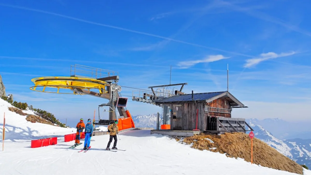 a couple of people standing on top of a snow covered slope