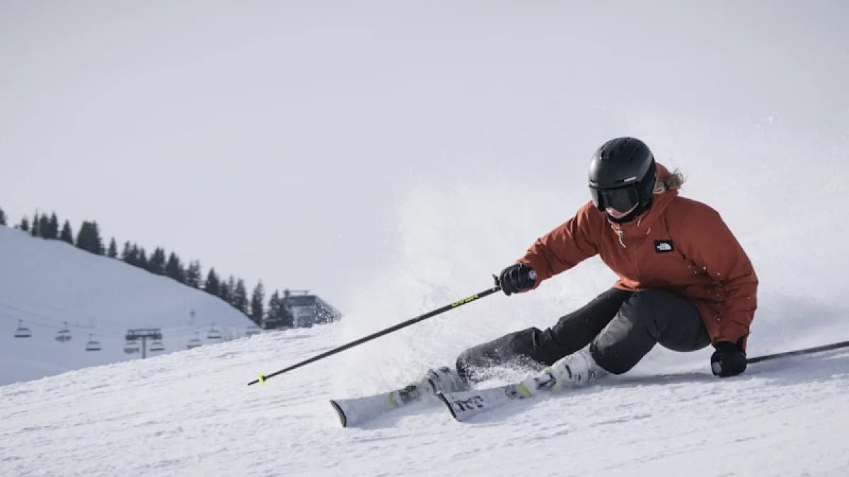 person in red jacket and black pants riding on snow board during daytime
